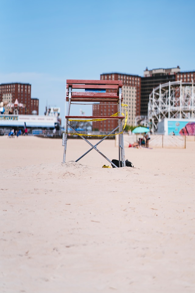 A raised red wooden chair on a beach.